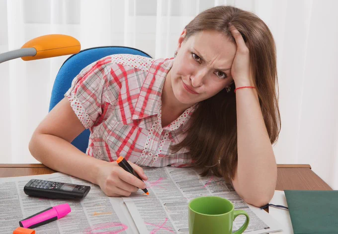 Girl with a newspaper looking frustrated