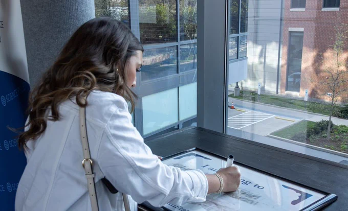 Girl writing down her next academic stop on a whiteboard.
