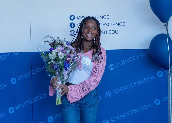 Girl posing with a bouquet of flowers at the Prehealth Accepted Student Celebration.