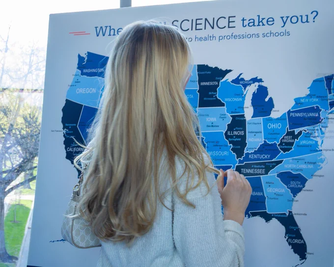 Girl placing a pin on a map indicating where she's going next in her career.