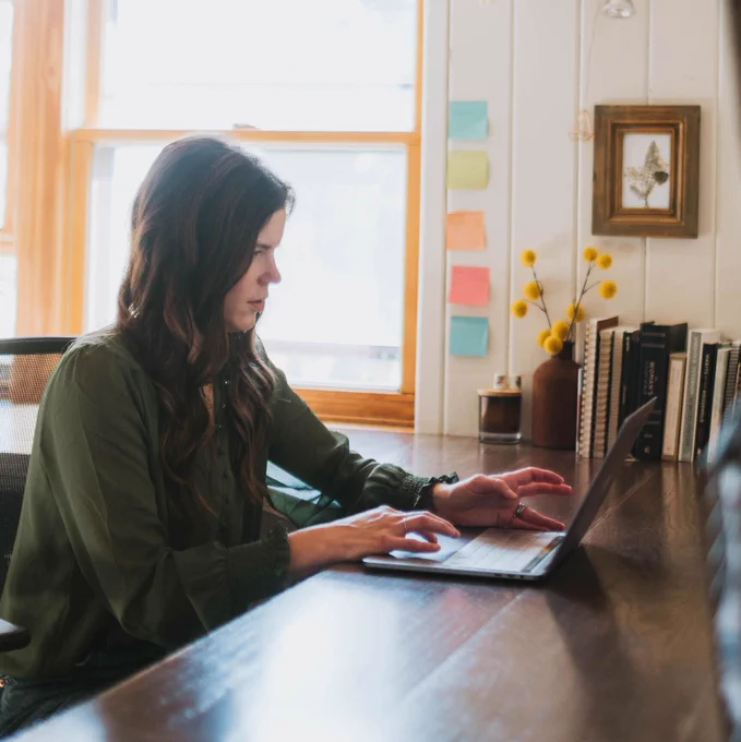 Women sitting at desk working on computer. 