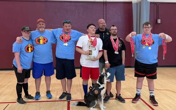 A member of the Douglas County Sheriff's Office is with a Special Olympics team.
