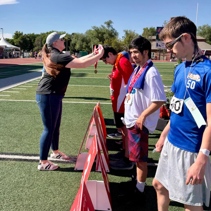 A member of the Douglas County Sheriff's Office is giving a medal to an athlete. 