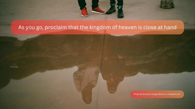 A picture of the feet of two people standing next to each other beside a puddle. Their faces are reflected in the puddle. The text reads: “As you go, proclaim that the kingdom of heaven is close at hand.”