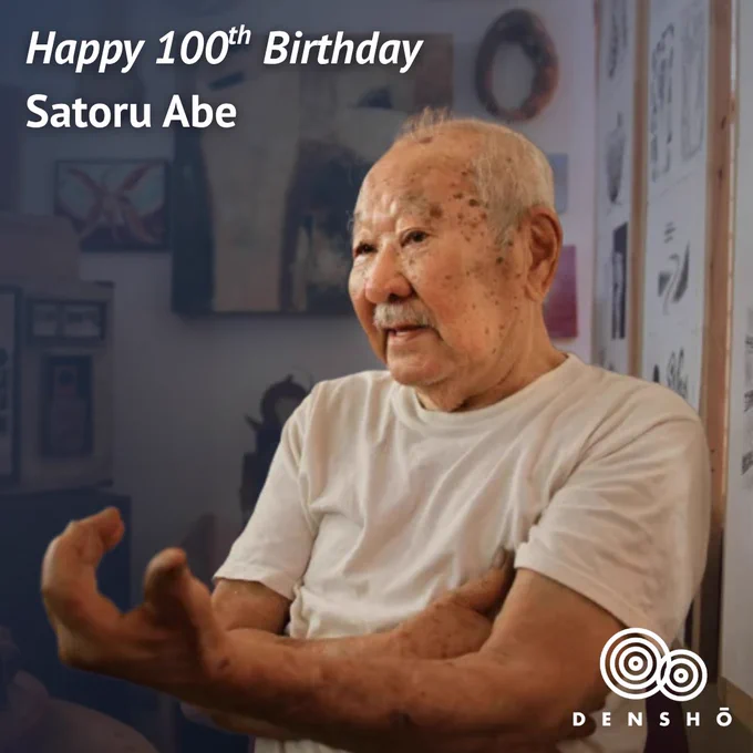 Densho branded graphic, text in the top left-hand corner reads: "Happy 100th Birthday Satoru Abe". Portrait photo of Satoru Abe in an art gallery that has white walls with various artworks hanging. The background is faded slightly with a navy hue. 