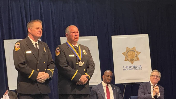 CAL FIRE Chief Joe Tyler stands next to an award recipient. 