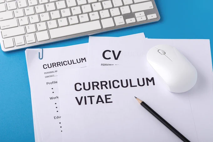 Keyboard with a blank CV, pencil and computer mouse.
