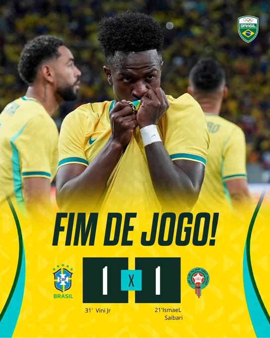 The image shows a Black soccer player wearing a yellow Brazilian national jersey, with a pained expression and hand covering his mouth, celebrating after a soccer match.