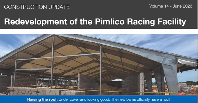 The image shows a construction update for the Pimlico Racing Facility redevelopment. It features a large, partially constructed barn with a new roof. Building materials are visible on-site, and the structure is surrounded by a safety barrier.