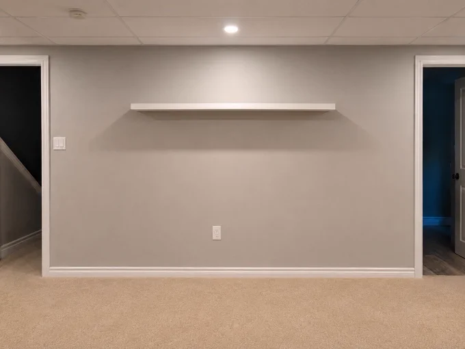 Empty wall with a single floating shelf. 