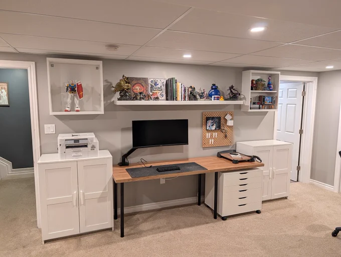 Finished basement workspace. Cabinets, monitor arm, and a custom cut and installed IKEA kitchen countertop. 