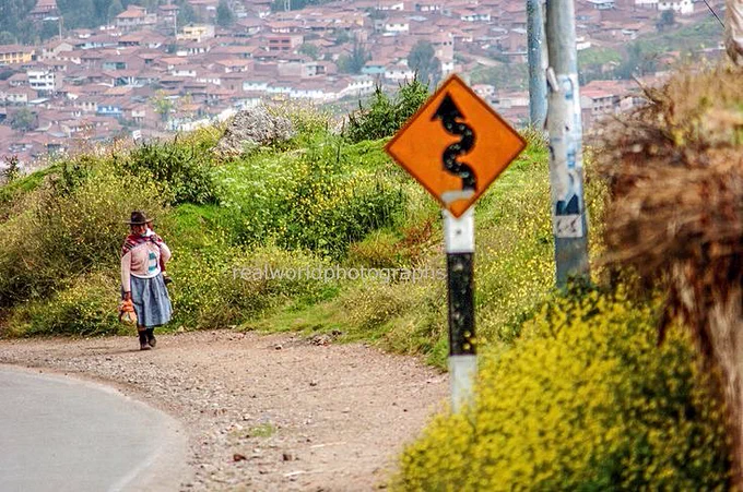 A Peruvian woman makes her way up a steep road over looking Cusco, Peru, South America. Gary Moore photo. Real World Photographs. #photojournalism #Grok #Peru #Cusco #travel #Nikon #SouthAmerica  #realworldphotographs #streetphotography #documentary #garymoorephotography
