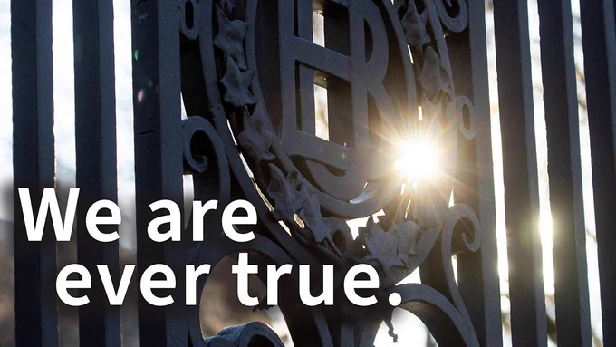 Close-up of Brown University's historic Van Wickle Gates, with sunlight shining through the ironwork. White text over the image reads, "We are ever true."