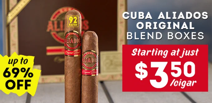 Image of two cigars with red and gold bands labeled "Cuba Aliados." The text on the image mentions "Cuba Aliados Original Blend Boxes" with a promotional offer of "up to 69% off" and a starting price of "$3.50 per cigar. - Cigars International