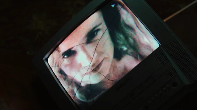 From Cape Fear. Juliette Lewis removes the hoodie and face mask to reveal herself as the woman on the television that is now cracked.