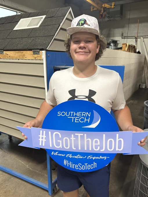 student holding an I got the job sign