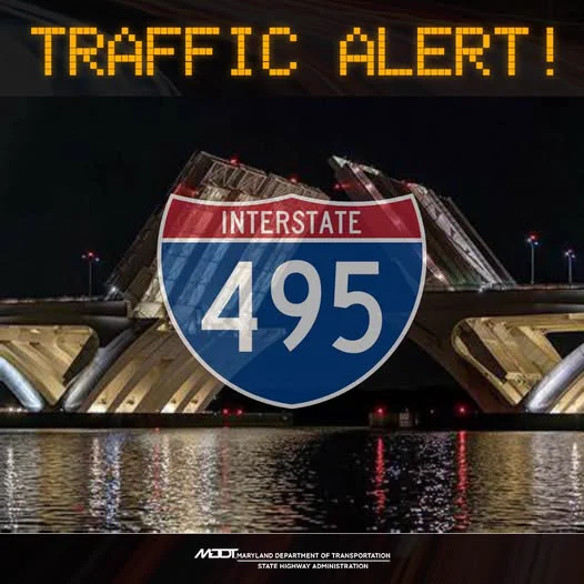 Night view of the raised Woodrow Wilson Drawbridge over water with a glowing 'TRAFFIC ALERT!' sign and Interstate 495 shield overlay.