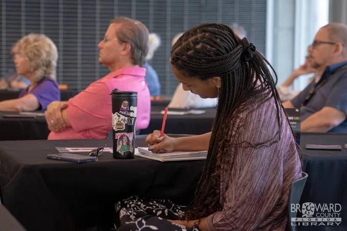 A woman taking notes during a presentation
