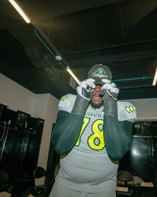 A football player in a locker room celebrates a championship victory, wearing a hat and gloves. The mood is victorious and celebratory.