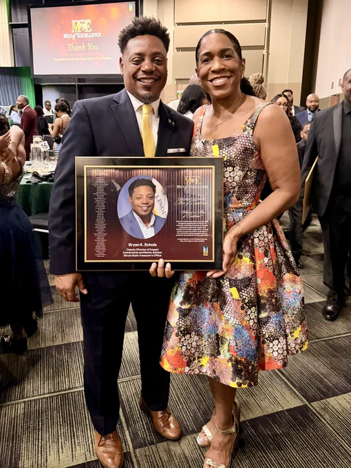 Lt Gov Juliana Stratton and Second Gentleman Bryan Echols smiling and holding his Men of Excellence plaque.