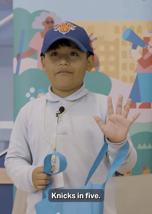 Student holding up five fingers with the caption “Knicks in five.”