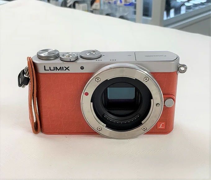 手のひらに収まるほど非常に小さなミラーレス一眼カメラ、Panasonic LUMIX GM1のオレンジカラー。クラシカルなシルバーの金属トップと、鮮やかなオレンジ色のレザー調の外装が特徴的な、レトロで可愛らしいデザインです。
​
​A palm-sized, ultra-compact mirrorless camera, the Panasonic LUMIX GM1 in orange. It features a retro and stylish design with a classic silver metal top and a vibrant orange leather-toned body.