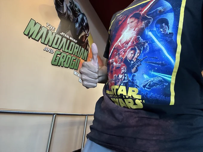 Me posing with a thumbs up next to a large decal for Star Wars: The Mandalorian and Grogu. I’m donning a t-shirt with the poster artwork for Star Wars: The Force Awakens (found it at a thrift shop two years ago).