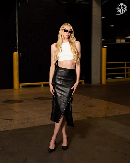 Cameron Brink wearing a white crop top and black leather skirt