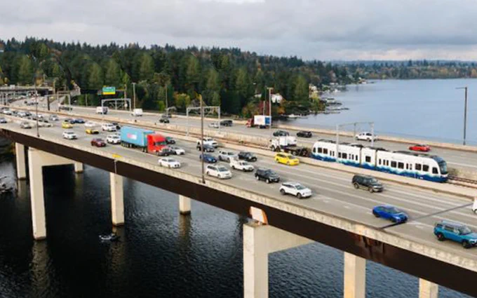 Light rail train crossing I-90 bridge into Bellevue surrounded by I-90 car traffic