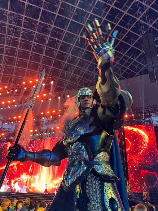 A traditional performer in ornate costume and face paint poses dramatically on stage during Fervor Taiwan's "Sacred Procession." Red lanterns, temple-inspired visuals, and fellow performers create a vibrant backdrop.