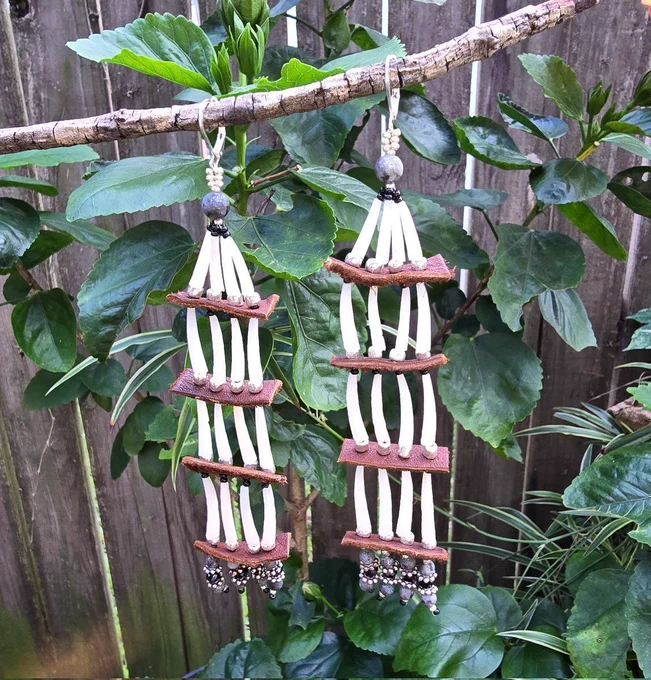 beaded earrings made with 4 tiers of white dentalium shells, black laboradorite, glass beads, brown moosehide, and silver-plated lever-back ear hooks