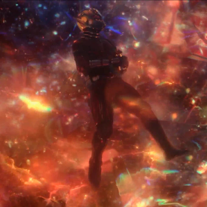 scott, holding a collection unit full of healing particles for ava, stranded in the quantum realm. he’s floating weightlessly and surrounded by colourful light