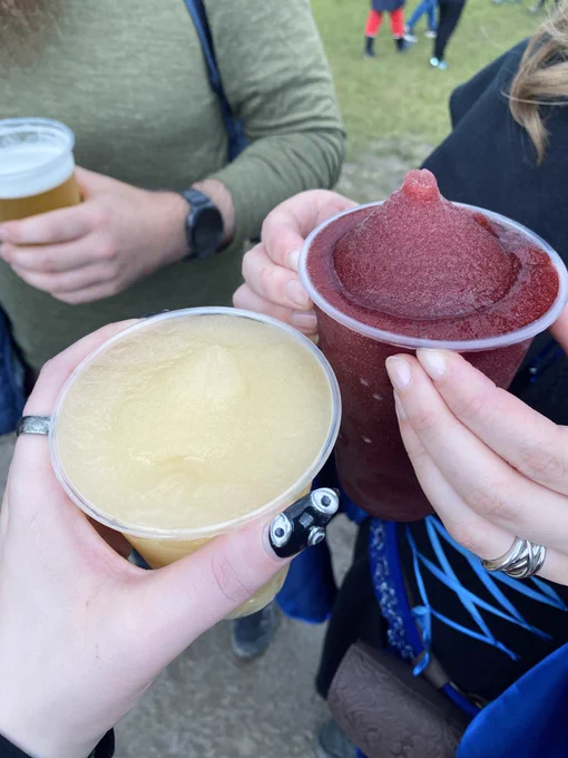 Photo of hands holding cups of slushies made with met.