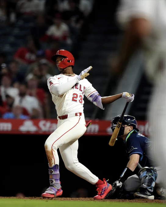 Denzer Guzman swings at a pitch, holding the bat in one hand as he finishes his swing. 