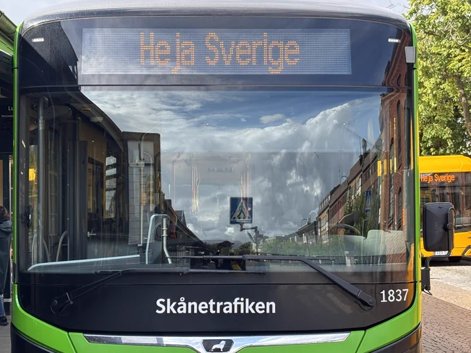 Grön stadsbuss där det står Heja Sverige i displayen och sedan bussens nummer och destination.