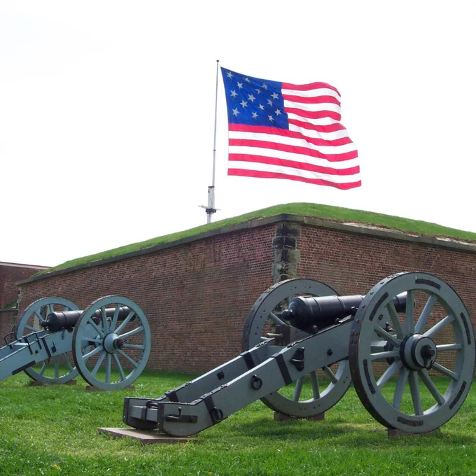Two field pieces in front of the fort with the Garrison Flag flying.
