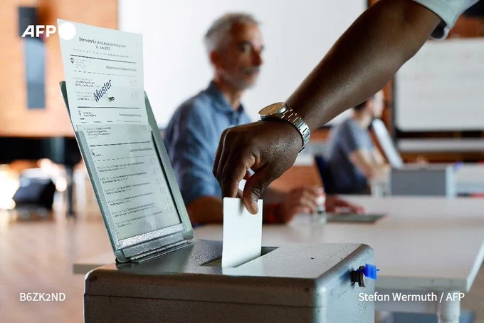 A citizen casts his ballot at a polling station in Bern, on June 14, 2026 as the Swiss vote on a divisive anti-immigration proposal to cap the country's population and another referendum on restricting access to conscientious objection to military service