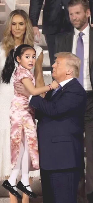 Pedophile Rapist Trump holding a young girl, that looks terrified.
