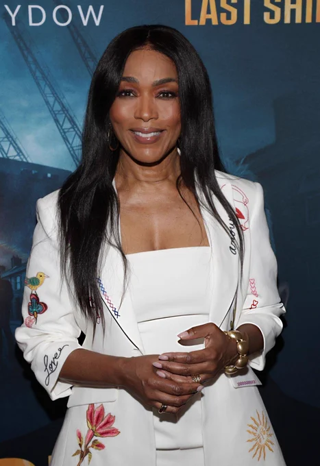 Angela Bassett in a floreal white outfit softly smiling