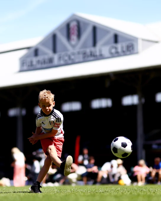 A young Fulham fan has a shot in front of the Johnny Haynes Stand.