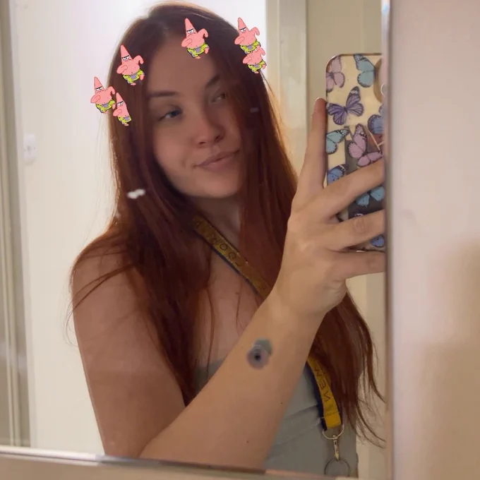 selfie of me from a while ago w my old phone case n a lil angry patrick star crown type filter <3