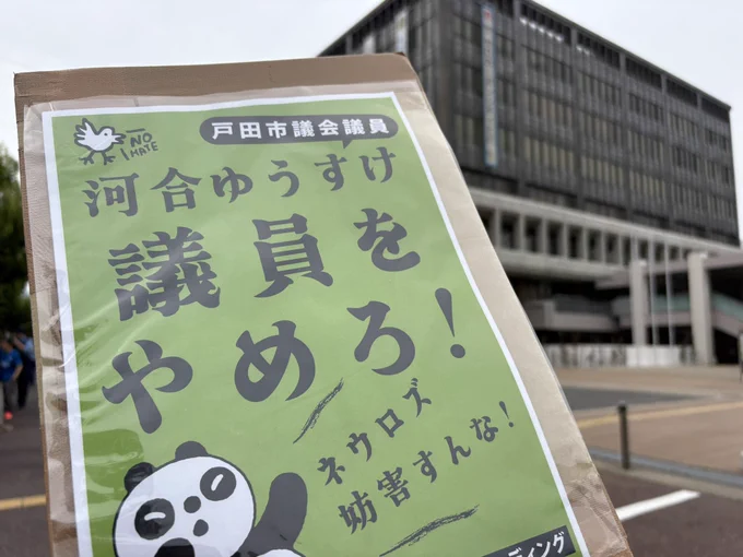 戸田市役所の前で、河合ゆうすけ議員の辞職をもとめるプラカードを掲げて写真を撮った