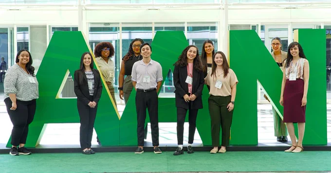 Group of AAN Members in front of green AAN letters