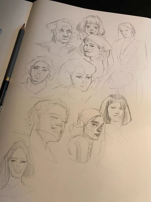A sketchbook page with a series of messy portraits in pencil. The figures all show a bunch of different expressions and features. 