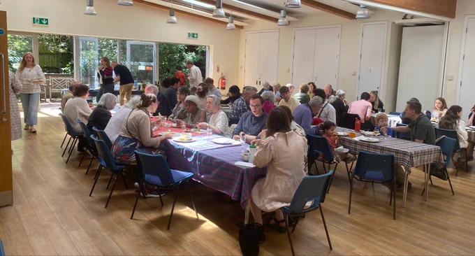 The meal in the hall after the service. Lots of people sitting at tables.