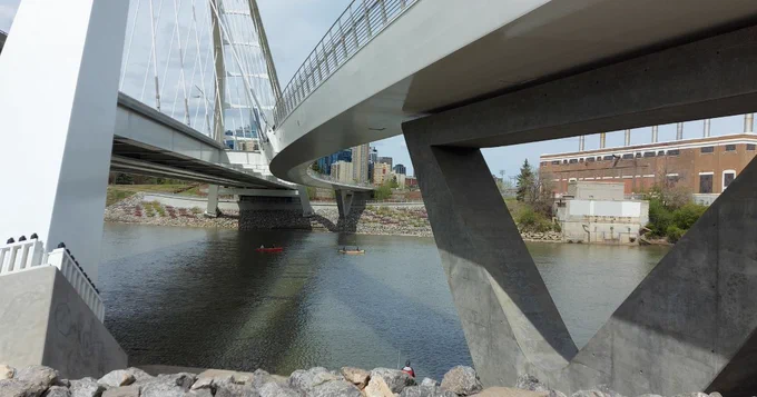 South base of the Walterdale Bridge with canoes in the river and Rossdale Plant in the background