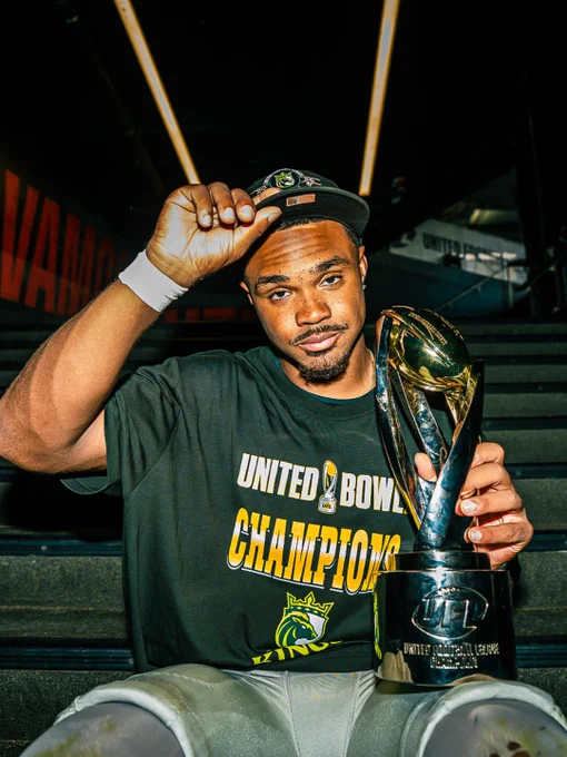 A football player celebrates winning the United Bowl by holding up a trophy and tipping his cap. The image conveys a victorious and proud mood.