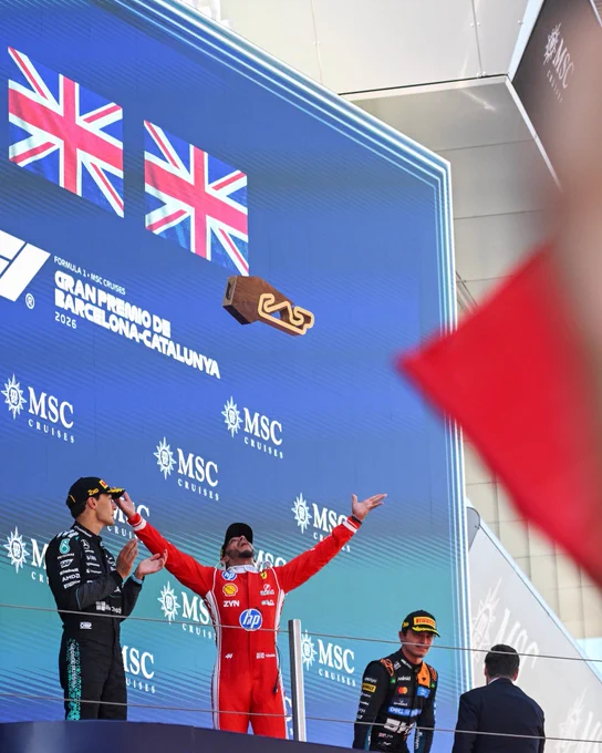 Lewis Hamilton celebrates his win at the Barcelona Race, in the middle of Lando Norris and George Russell on the podium.