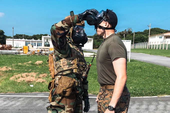 U.S. Air Force Staff Sgt. Tyler Lebbert, an Emergency Management specialist with the 773d Civil Engineer Squadron, 673d Air Base Wing, removes an M50 Joint Service General Purpose Mask from U.S. Marine Corps Lance Cpl. Montgomery Henderson, a chemical, biological, radiological and nuclear (CBRN) defense specialist with Headquarters Battalion, 3rd Marine Division, as part of decontamination procedures during a simulated biological response scenario in exercise Toxic Wave 26 at Marine Corps Air Station Futenma, Okinawa, Japan, May 30, 2026. Toxic Wave 26 is a joint CBRN defense exercise hosted by Marine Wing Support Squadron 172 in partnership with Pacific Air Forces and multiple Air National Guard units. Conducted across Okinawa, the exercise enhances interoperability and strengthens readiness to respond to evolving threats throughout the Indo-Pacific region. (U.S. Marine Corps photo by Cpl. Jeremiah Barksdale)\n\n