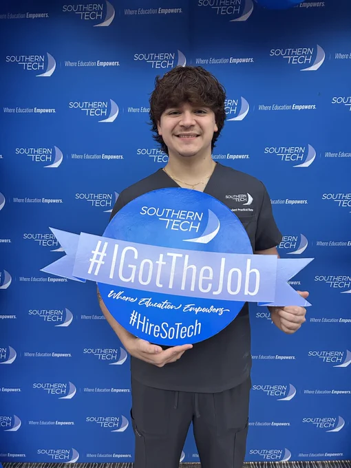 student holding an I got the job sign.